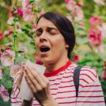 Alergia respiratoria - mujer joven estornudando